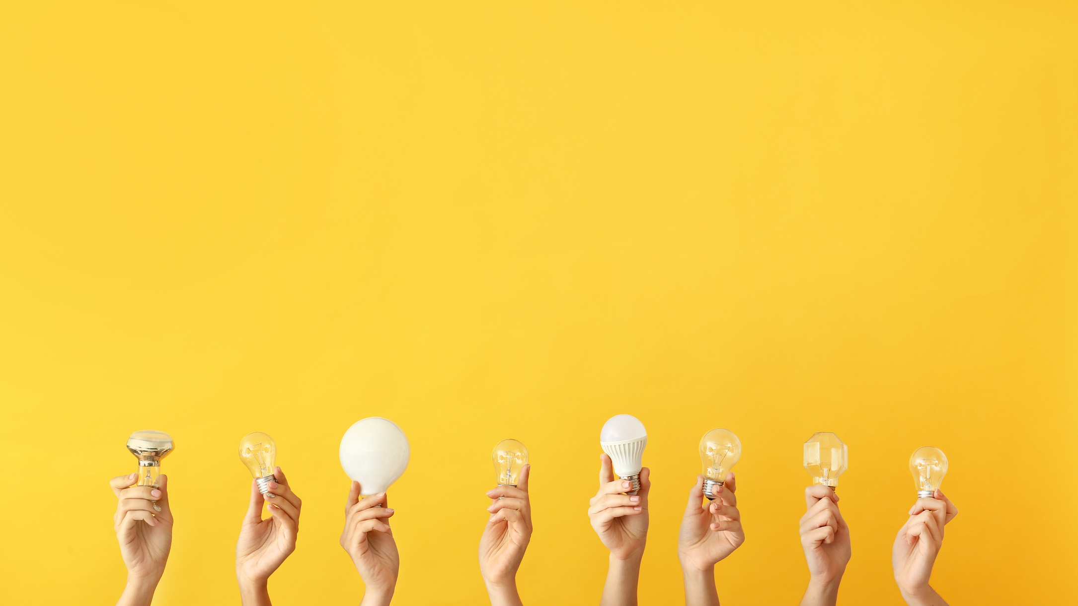 Female Hands with Electrician's Tools on Yellow Background